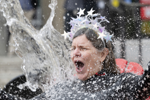 Glen de Vries Dean of the Mellon College of Science Barbara Shinn-Cunningham gets doused with a wave of water as she sits in a star dress.