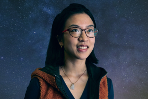 Nianyi Chen stands against a galaxy background.