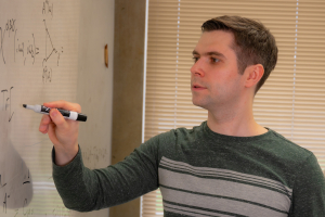 Vlad Kozii writes equations on a whiteboard in his office.