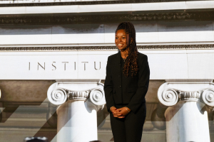 Ashley Hackney stands on stage during her speech at the CMU125 celebration. She smiles at the audience.