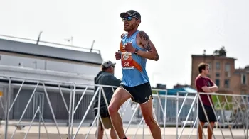 Colin Martin runs past bystanders during a marathon.