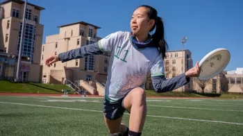 Sara Liang knees on the field at Gesling Stadium.