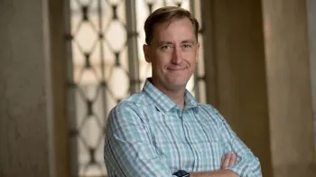 Matthew Smith stands in Mellon Institute and smiles at the camera.