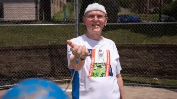 Image of a man swinging a weighted ball on a chain.