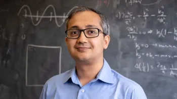 Man standing in front of a blackboard.