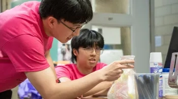 Eugene Yoon and Aramchan "Chamy" Lee guess the number of Eppendorf tubes in a container during the Bio Lab Olympics.